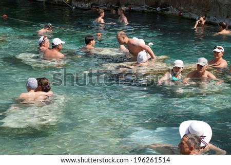 PAMUKKALE, TURKEY - MAY 27, 2014 - Russians and other tourists swim in the thermal pools amidst ancient Roman columns of the spa at Pamukkale Turkey
