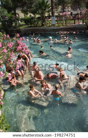 PAMUKKALE, TURKEY - MAY 27, 2014 - Russians and other tourists swim in the thermal pools amidst ancient Roman columns of the spa at Pamukkale Turkey