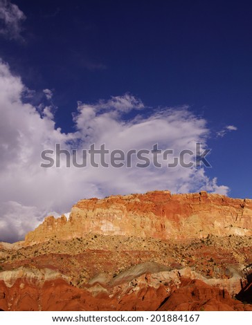 Golden Throne, with bright blue sky and growing  thunder clouds in background, Capitol Reef National Park, Utah