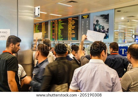 ISTANBUL, TURKEY - MAY 15, 2014 -Arriving passengers run the gauntlet of travel guides as they exit customs area of the airport  in Istanbul, Turkey