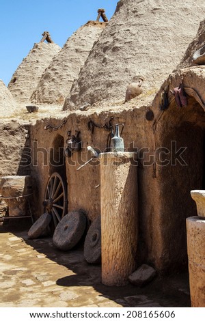 Traditional beehive mud brick houses with farm tools, Harran near the Syrian border, Turkey