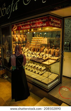 BURSA, TURKEY - MAY 22, 2014 - Women with scarves choosing gold bracelets  in the bazaar of  Bursa, Turkey