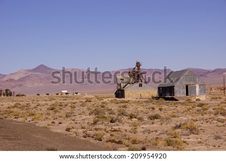 Old mining buildings, rusting in the desert,with mountains in background, Nevada