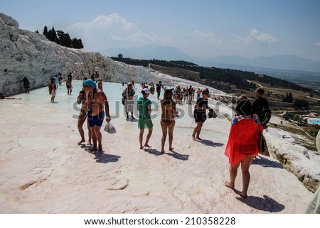 PAMUKKALE, TURKEY - MAY 27, 2014 - Tourists in bikinis play in the turquoise pools of travertine deposits in  Pamukkale,  Turkey