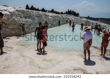 PAMUKKALE, TURKEY - MAY 27, 2014 - Tourists in bikinis play in the turquoise pools of travertine deposits in  Pamukkale,  Turkey