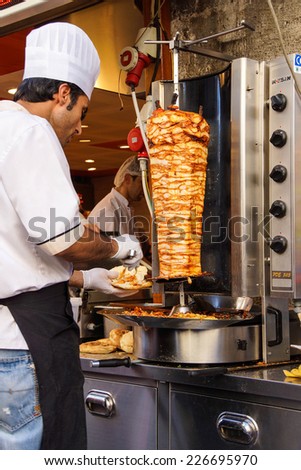 ISTANBUL - MAY 17, 2014 - Cook slices meat from the turning spit for shawarma doner kababs  in Istanbul, Turkey