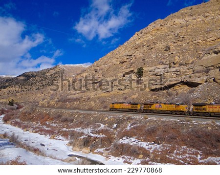 GLENWOOD CANYON, COLORADO - JAN 31, 2013 -Freight train runs through a narrow canyon in winter, Glenwood Canyon,  Colorado