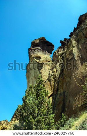 Tiny climbers on the overhanging  cliff of Monkey Face, Smith Rock State Park, Central Oregon