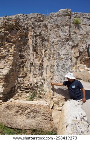 PERGE, TURKEY - JUN 2, 2014 - Turkish guide points out the sewer system  in the ancient Greek city of Perge   Turkey