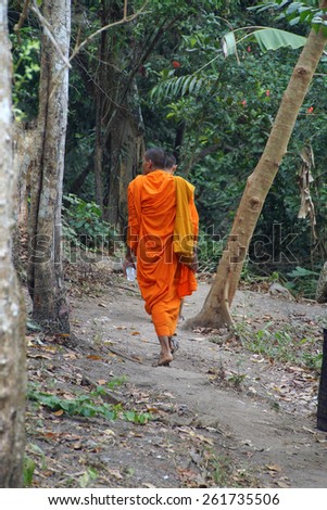 Two young Buddhist monks in saffron robes on a jungle trail,  Phnom Kulen, Cambodia