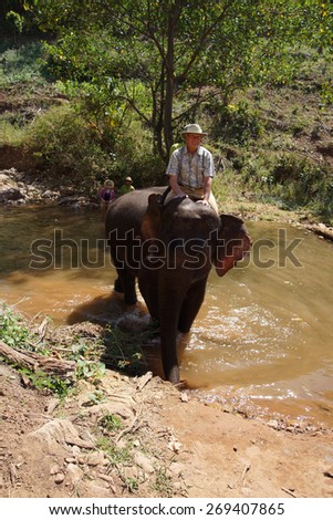 KALAW, BURMA - FEB 27, 2015 - Tourist rides an elephant in the  Elephant conservation camp near Kalaw Myanmar (Burma)