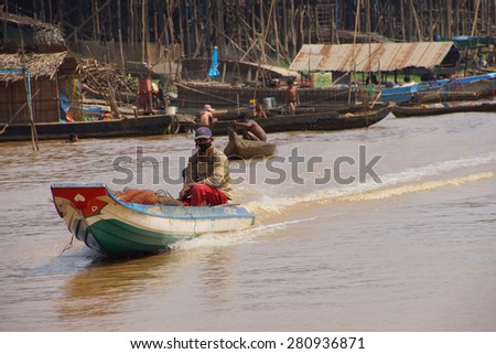 KOMPONG KLEANG, CAMBODIA - FEB 12, 2015 - Power boat travels along the waterway of Kompong Kleang floating fishing village,  Cambodia