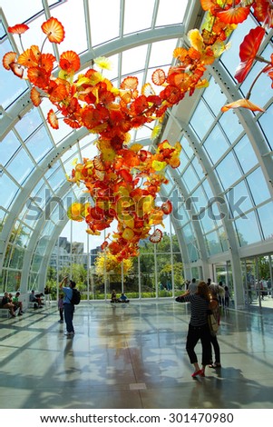 SEATTLE - JUL 23, 2015 - Tourists admire the Glass flowers in the  conservatory sunlight of the Chihuly Garden and Glass Museum,  Seattle, Washington