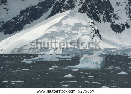 Icebergs, brash ice, mountain icefall and glacier,		Lemaire Channel,	Antarctica