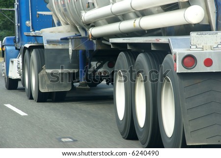 Blue semi truck with tanker, 		speeding down highway