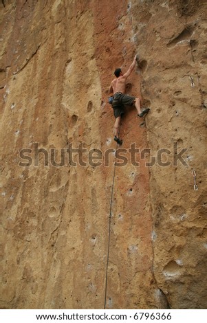 Bare back climber clinging to rock face,		Smith Rock State Park, 	Central Oregon