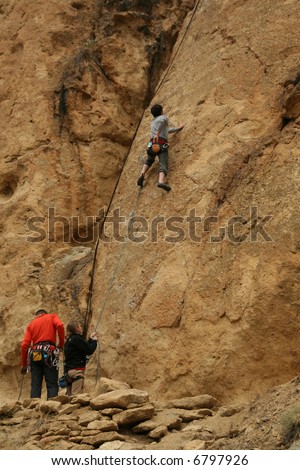 Woman belaying a climber on rock face,		Smith Rock State Park, 	Central Oregon
