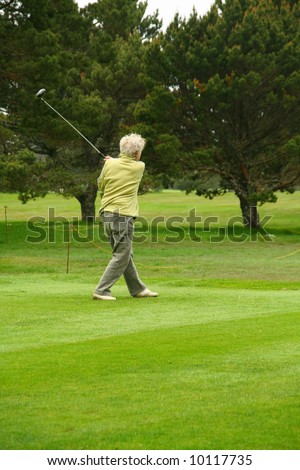 Woman golfer teeing off,		Agate Beach Golf Course, Newport,	Oregon coast