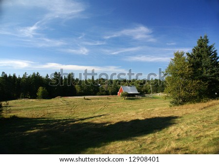 New England red barn and fence against blue sky.			Mount Desert Island, Acadia National park, Maine, New England