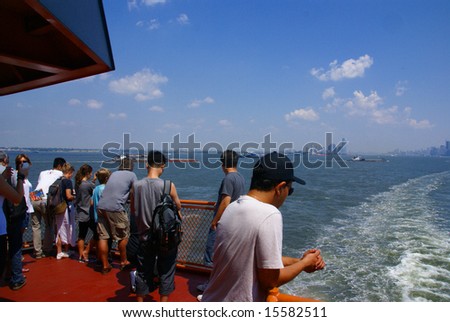 Sightseers, tourists on front of 	Staten Island Ferry,		New York City