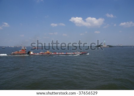 Tugboat pushing barge in New York Harbor, from Staten Island Ferry,  New York City