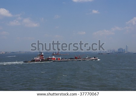 Tugboat pushing barge in New York Harbor, from Staten Island Ferry,  New York City