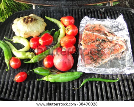 Pacific Northwest barbecue - salmon on foil, tomatoes, squash and peppers on a grill