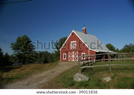 New England red barn and fence against blue sky.   Mount Desert Island, Acadia National park, Maine, New England