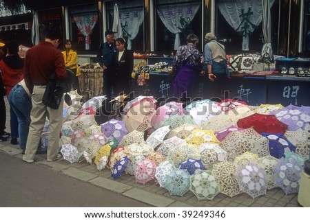 BEIJING - CIRCA NOV : Tourists shop for umbrellas on a rainy day circa November 2001 in Beijing.