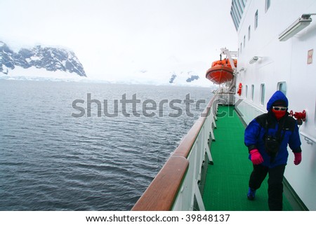 Tourists on promenade deck of cruise ship, watching glaciers, 		Erreras Channel, 	Antarctica
