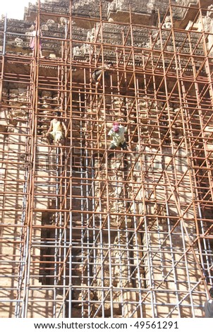 PURI, INDIA - NOV 18 -  Workers climb iron scaffolding to work on restoration of the ancient Hindu temple of Konark   on Nov 18, 2009  in Puri, India