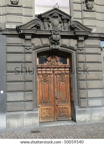 Old wooden doors on solid stone building   in Geneva, Switzerland.