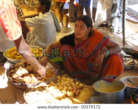 ORISSA INDIA - NOV 10  - Woman prepares fried food for snacks at a  weekly market on Nov 10, 2009 in Orissa, India