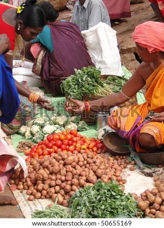ORISSA,  INDIA - NOV 12 - Indian woman selling potatoes and other vegetables  at a weekly market on Nov 12, 2009 in Ankadeli, Orissa in India