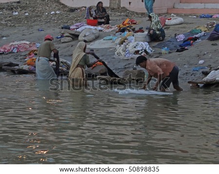 VARANASI, INDIA - NOV 6 -  Dhobiwallahs wash clothes in the Ganges River  on Nov 6, 2009,  in Varanasi, India.