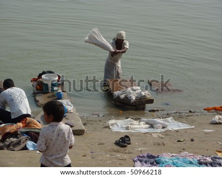 VARANASI, INDIA - NOV 7 -  Dhobiwallah washes clothes in the Ganges River  on Nov 7, 2009,  in Varanasi, India.