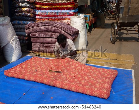 VARANASI, INDIA - NOV 7 - Men sew large mattress covers in their shops on Nov 7, 2009, in Varanasi, India.