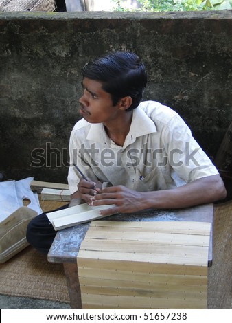 PURI, INDIA - NOV 15 - Student practises engraved calligraphy on palm leaves on Nov 15, 2009 in Puri, India
