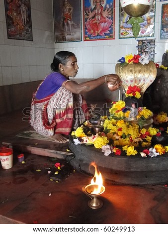 ORISSA INDIA - Nov 11:Temple guardian tends the altar of a small shiva temple on Nov 11, 2009 in Orissa, India