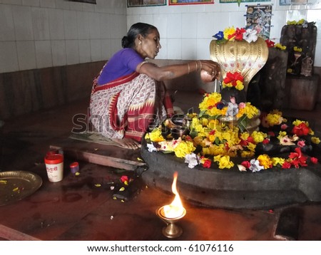ORISSA INDIA - NOV 11 -Temple guardian tends the altar of a small shiva temple on Nov 11, 2009 in Orissa, India