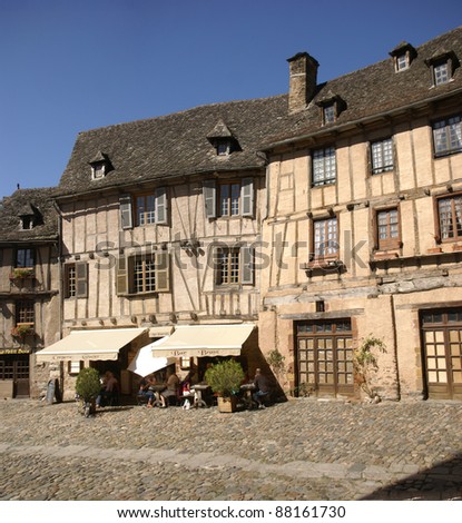 CONQUES, FRANCE - SEP 23 - Midday diners eat under the awning of a half-timbered house on Sep 23, 2011  in Conques, France