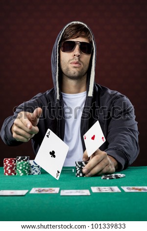 Poker player, on a red background, throwing two ace cards.