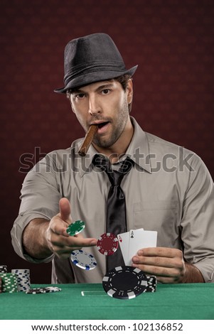 Poker player wearing hat and smoking a cigar, on a red background, throwing poker chips.