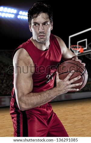 Basketball player with a ball in his hands and a red uniform. photography studio.