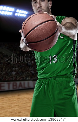 Brazilian Basketball player with a ball in his hands and a green uniform. photography studio.