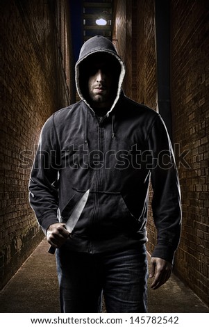 Thief in the hood on a dark alley