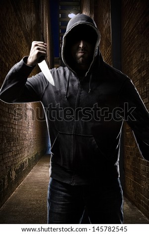 Thief in the hood on a dark alley