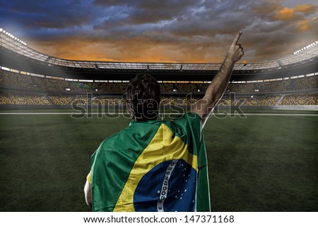 Brazilian Soccer Player With A Brazilian Flag On His Back, Celebrating With The Fans.