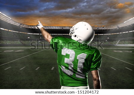 Football Player with a green uniform celebrating with the fans.