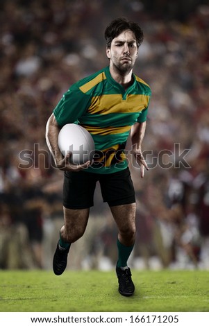 Rugby player in a green and gold uniform running on a stadium.
